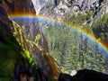 Rainbow arcing across Yosemite granite and forest from the Mist Trail