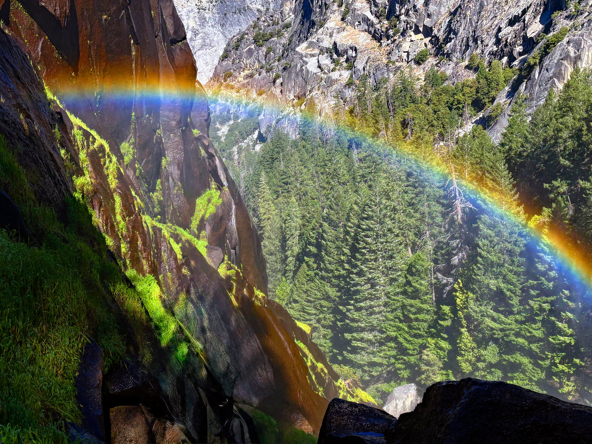 Rainbow arcing across Yosemite granite and forest from the Mist Trail