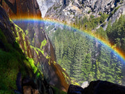 Rainbow arcing across Yosemite granite and forest from the Mist Trail
